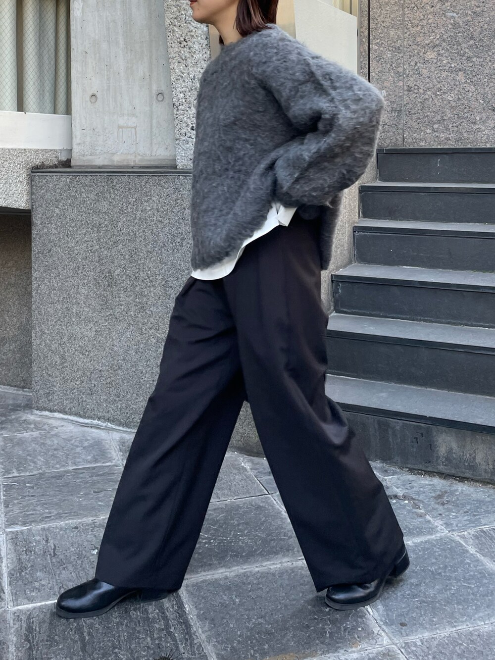 グレー系のニット/セーター、ブラック系のその他パンツを着用したレディースの冬コーディネートの2枚目の写真