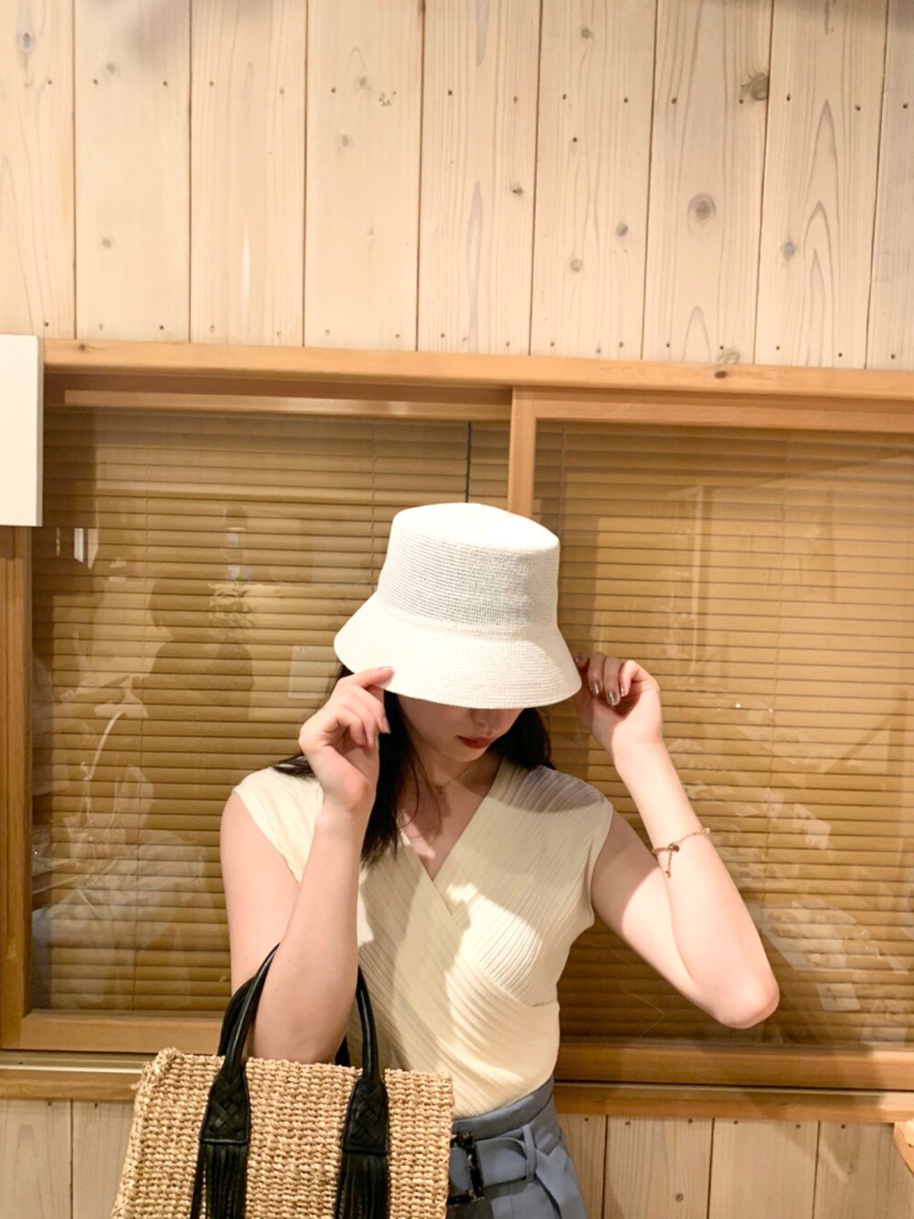 ホワイト系のニット/セーター、ブルー系のスラックス、ホワイト系のサンダルを着用したレディースの夏コーディネートの3枚目の写真