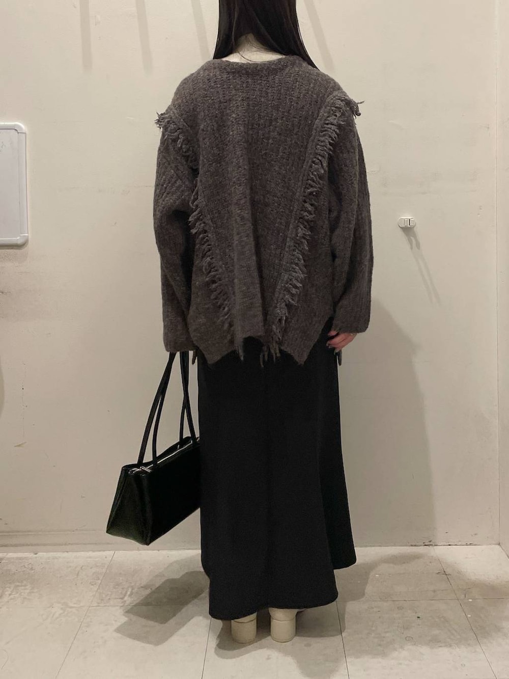 ホワイト系のニット/セーター、グレー系のニット/セーター、ホワイト系のブーツを着用したレディースの冬コーディネートの3枚目の写真