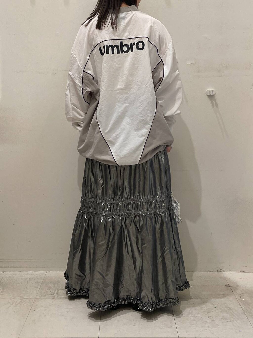 シルバー系のスカート、ブラック系のバレエシューズ、シルバー系のショルダーバッグを着用したレディースの秋コーディネートの2枚目の写真