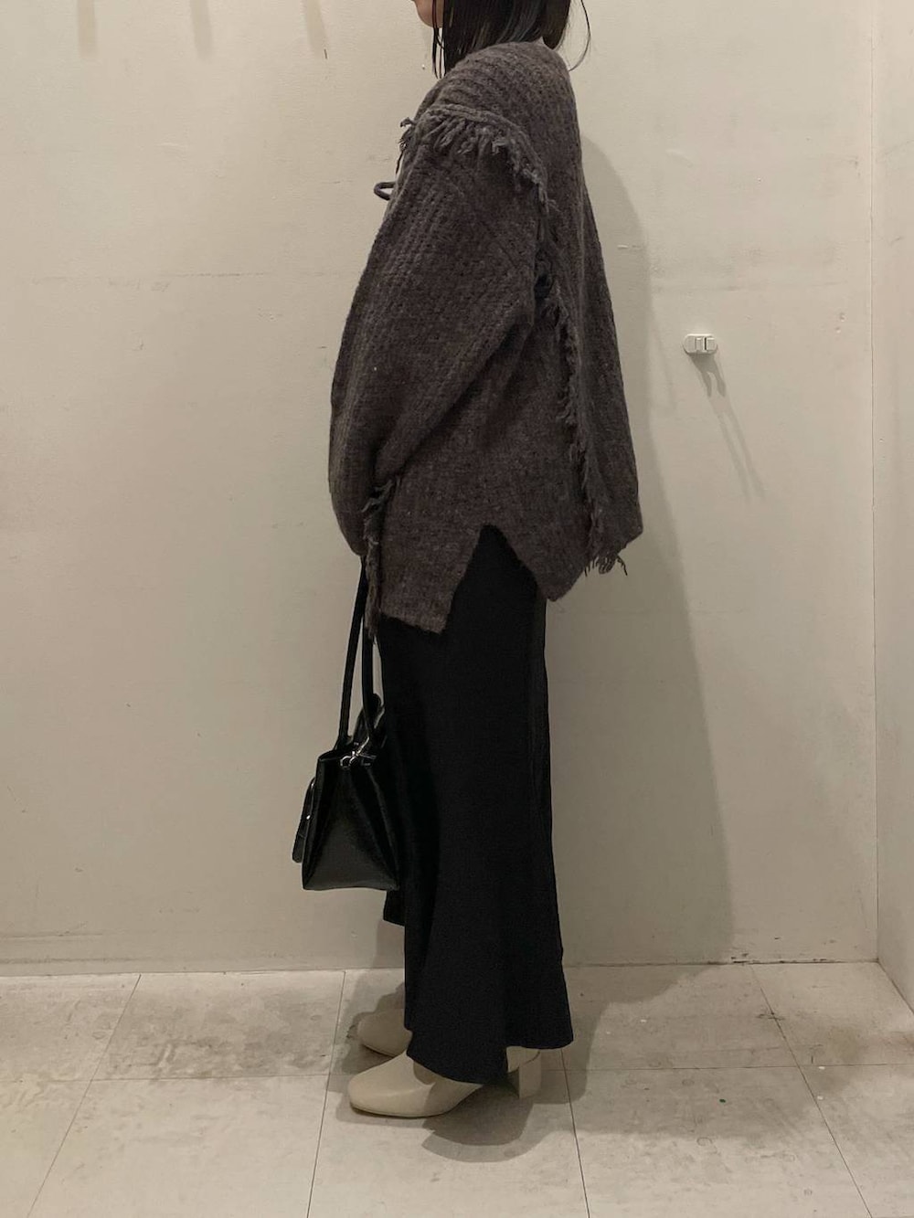 ホワイト系のニット/セーター、グレー系のニット/セーター、ホワイト系のブーツを着用したレディースの冬コーディネートの2枚目の写真