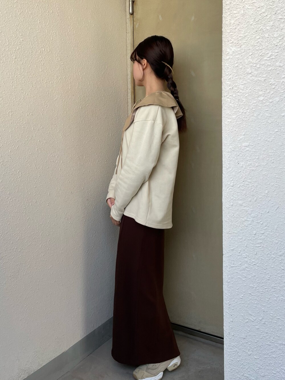 イエロー系のトップス、ブラウン系のワンピース、ベージュ系のスニーカーを着用したレディースの冬コーディネートの3枚目の写真