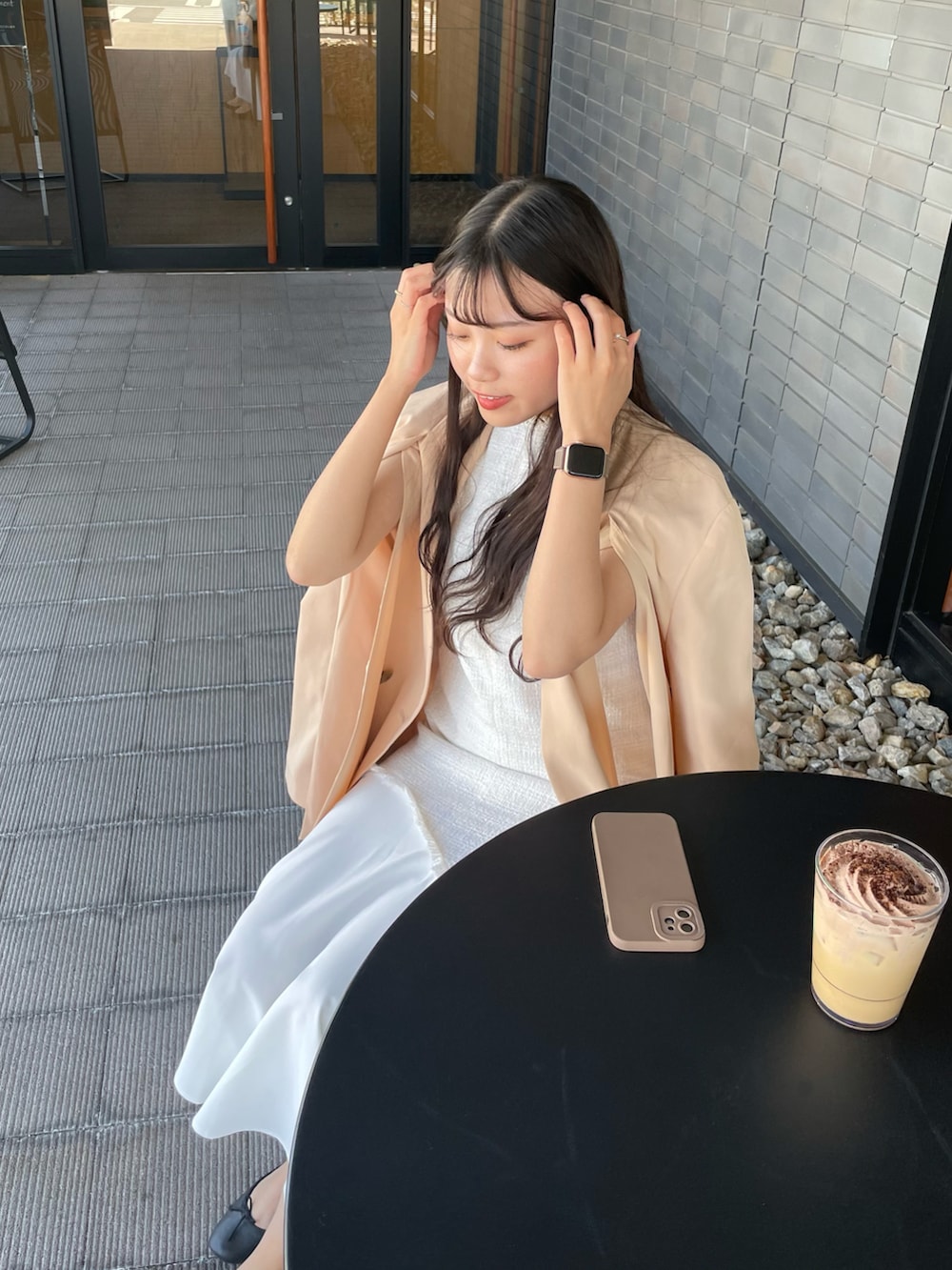 ベージュ系のテーラードジャケット、ホワイト系のワンピース、ブラック系のパンプスを着用したレディースの秋コーディネートの4枚目の写真