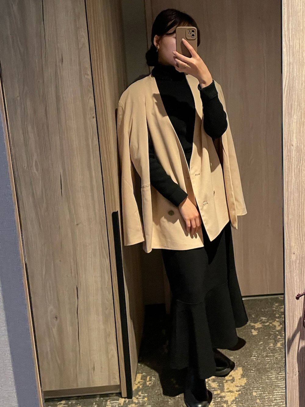 ベージュ系のテーラードジャケット、ブラック系のニット/セーター、ブラック系のスカートを着用したレディースの冬コーディネートの2枚目の写真