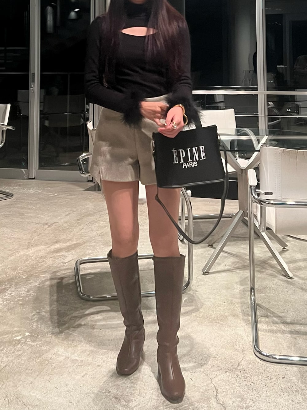 ブラウン系のブーツ、ブラック系のバッグ、ベージュ系のその他パンツを着用したレディースの冬コーディネートの2枚目の写真