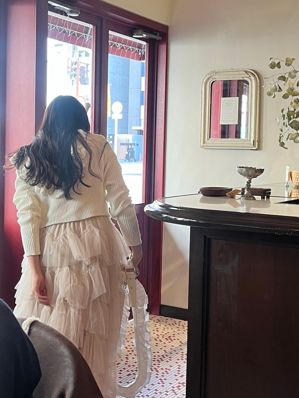 ホワイト系のスカート、ブラック系のブーツ、ホワイト系のカーディガン/ボレロを着用したレディースの冬コーディネートの2枚目の写真