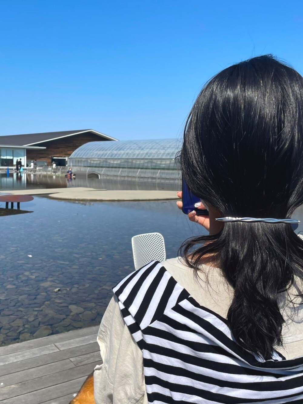 ブルー系のデニムパンツ、ホワイト系のTシャツ/カットソー、ブラック系のTシャツ/カットソーを着用したレディースの春コーディネートの2枚目の写真