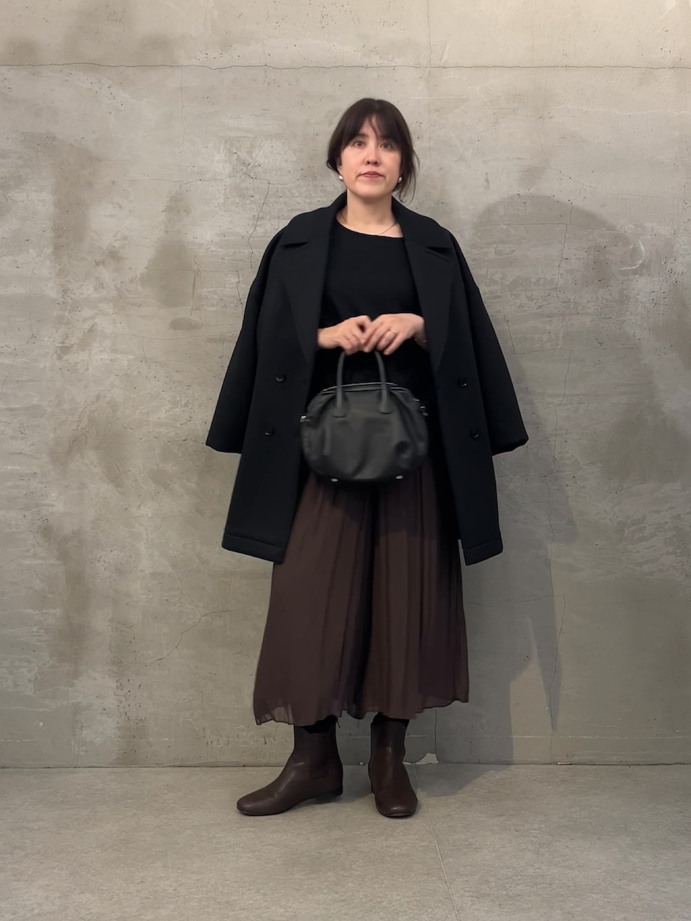 ブラック系のボストンバッグ、ブラウン系のその他パンツ、ブラウン系のブーツを着用したレディースの秋コーディネートの2枚目の写真