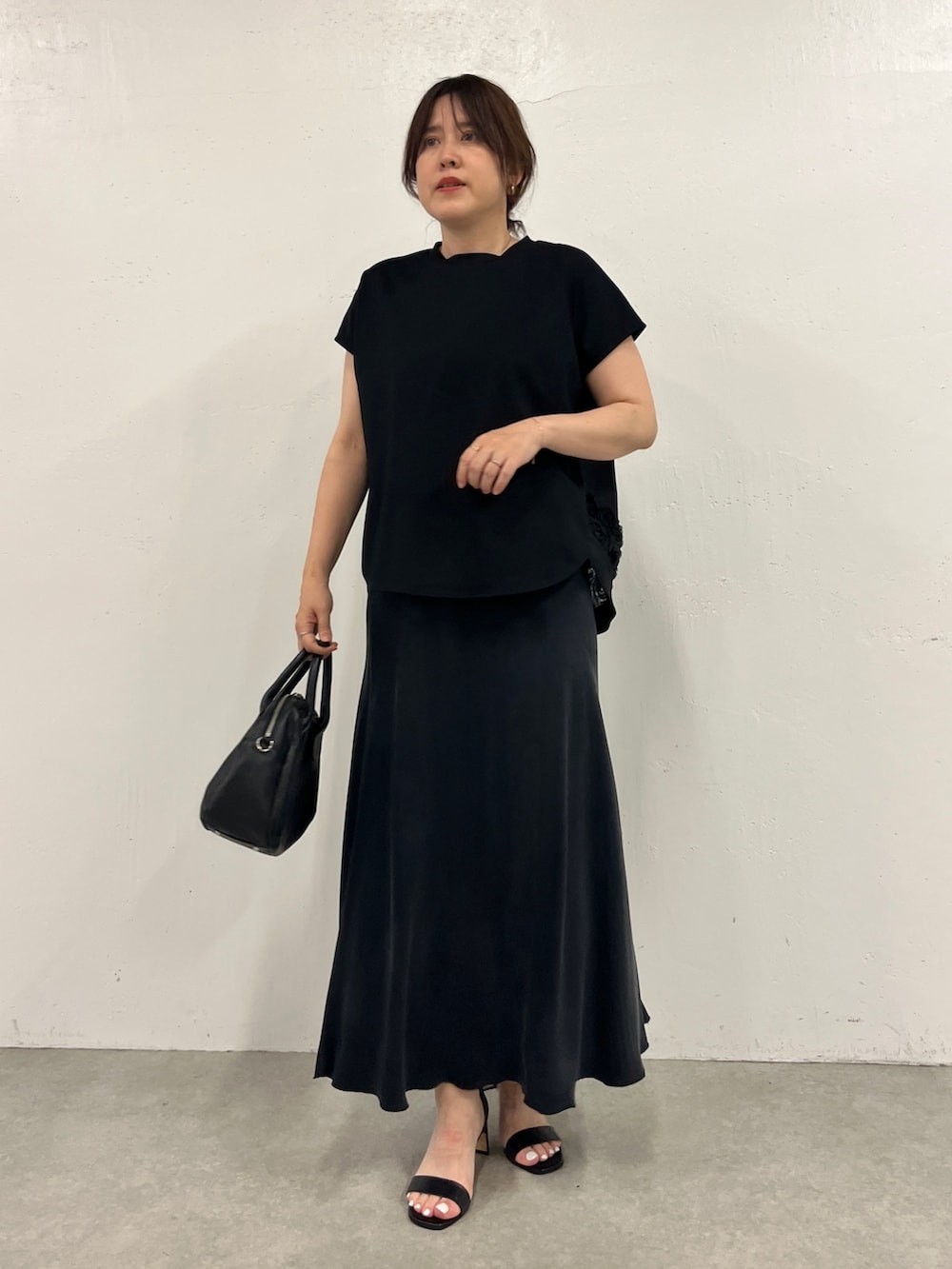 ブラック系のスカート、ブラック系のTシャツ/カットソーを着用したレディースの春コーディネートの3枚目の写真