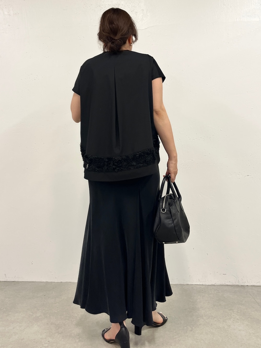 ブラック系のスカート、ブラック系のTシャツ/カットソーを着用したレディースの春コーディネートの2枚目の写真