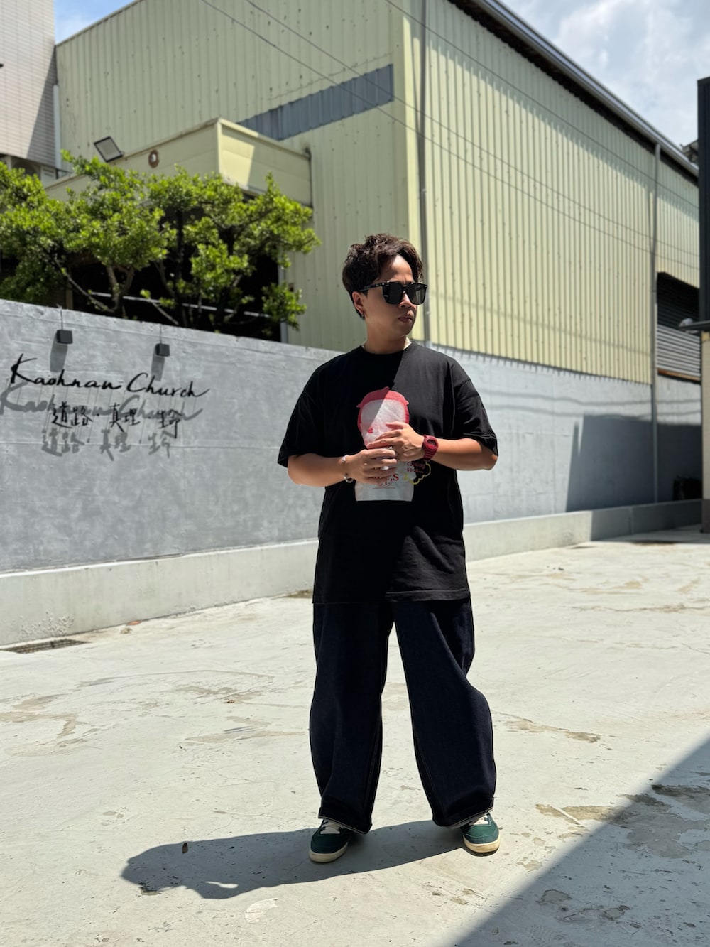 ブルー系のデニムパンツ、ブラック系のTシャツ/カットソー、グリーン系のスニーカーを着用したメンズの夏コーディネートの2枚目の写真