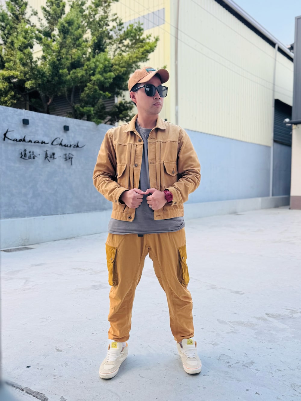 ベージュ系のライダースジャケット、イエロー系のカーゴパンツ、ホワイト系のスニーカーを着用したメンズの冬コーディネートの2枚目の写真