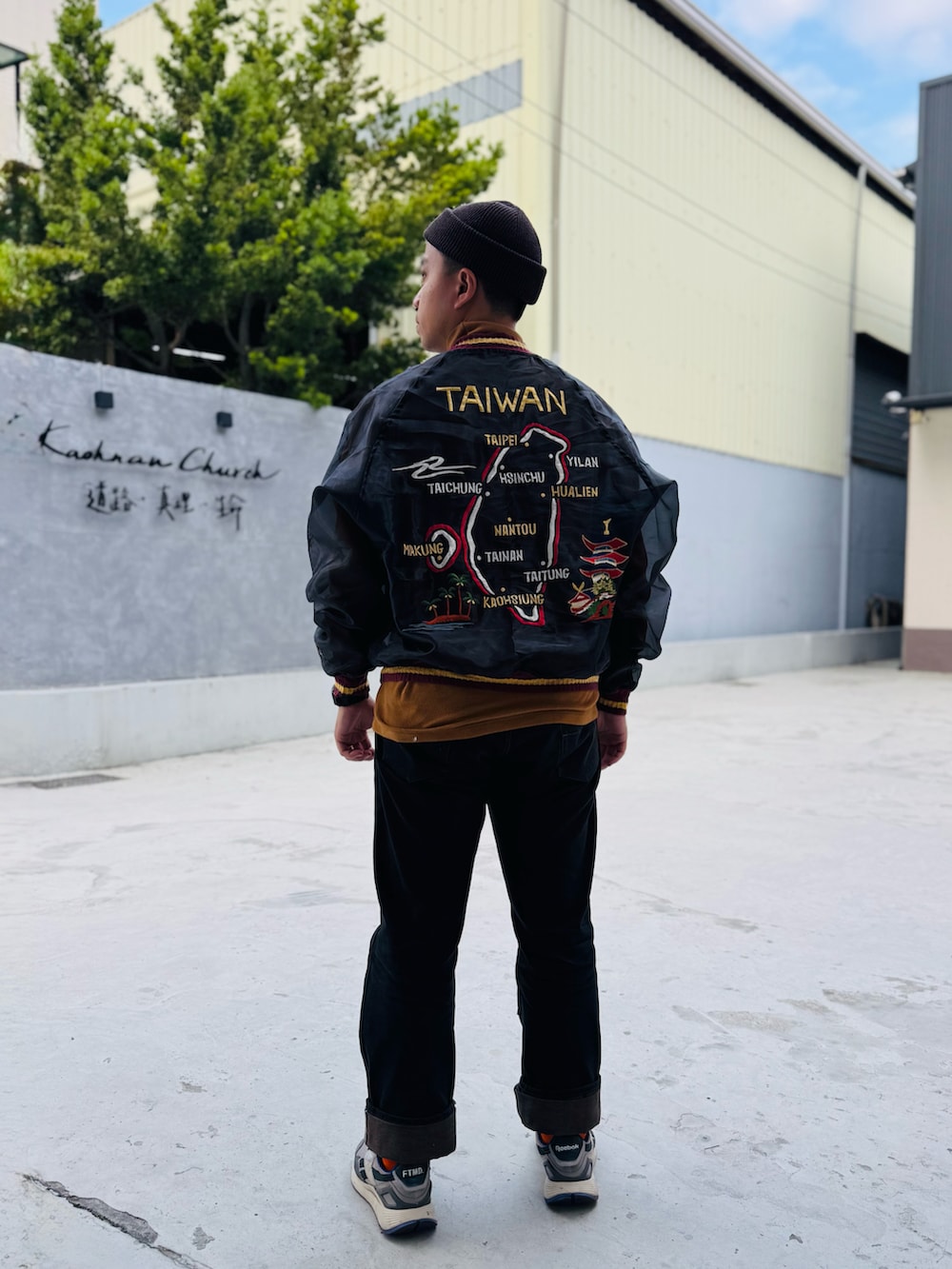 ブラック系のスカジャン、ブラック系のデニムパンツ、パープル系のスニーカーを着用したメンズの冬コーディネートの2枚目の写真