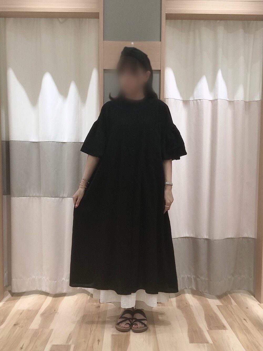 ブラック系のサンダル、ブラック系のワンピースを着用したレディースの夏コーディネートの2枚目の写真