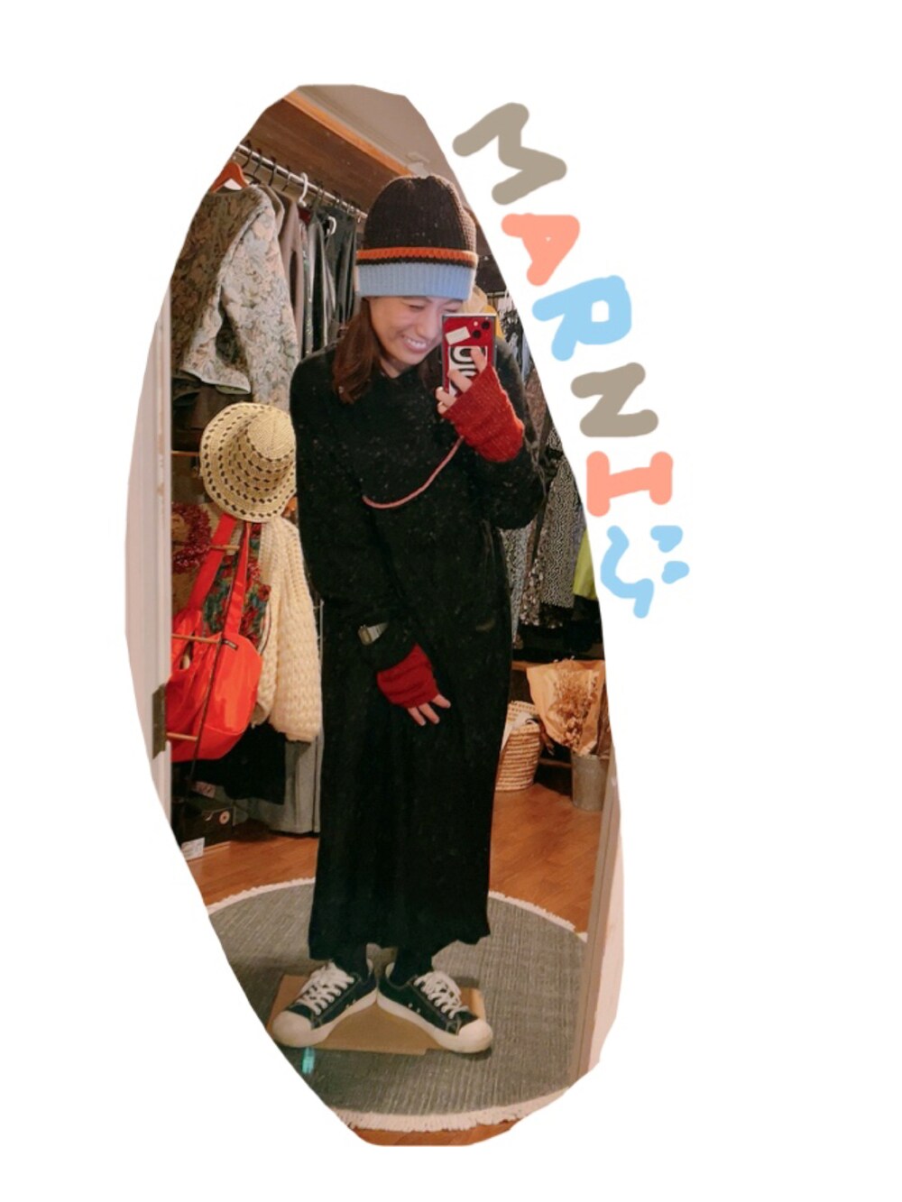 ブラック系のスニーカー、ブラック系のワンピース、レッド系のアームカバーを着用したレディースの冬コーディネートの2枚目の写真