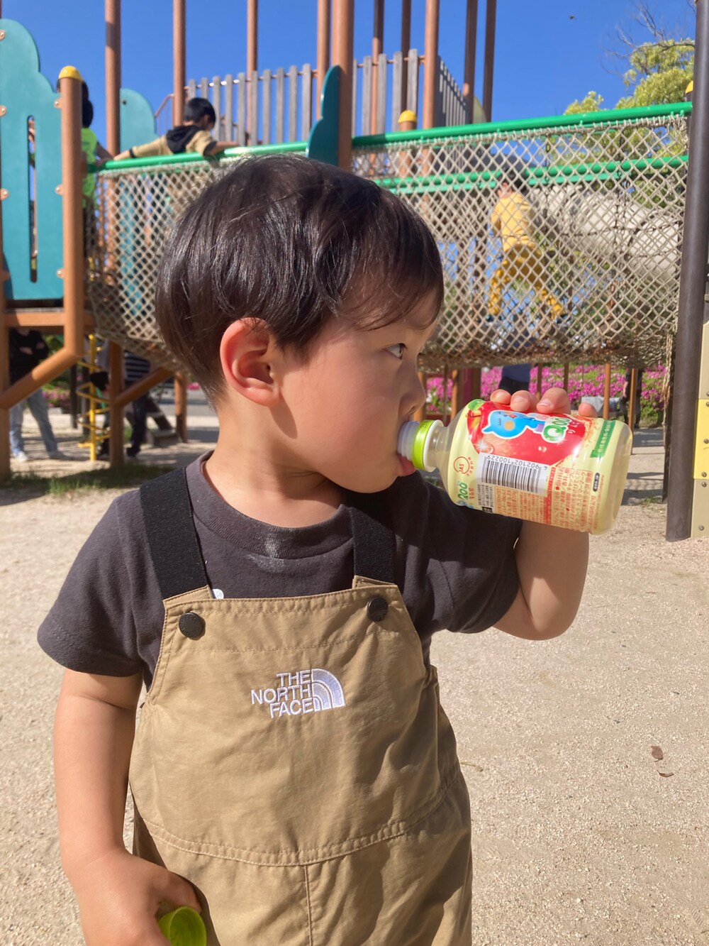 ブラック系のスニーカー、ベージュ系のサロペット/オーバーオールを着用したキッズの夏コーディネートの2枚目の写真