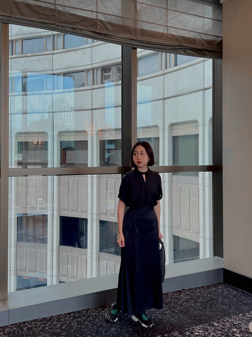 ブラック系のスカート、ブラック系のスニーカー、ブラック系のシャツ/ブラウスを着用したレディースの夏コーディネートの3枚目の写真