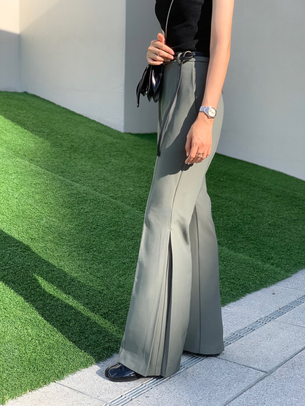 ブラック系のトップス、ブラック系のショルダーバッグ、グリーン系のその他パンツを着用したレディースの夏コーディネートの2枚目の写真