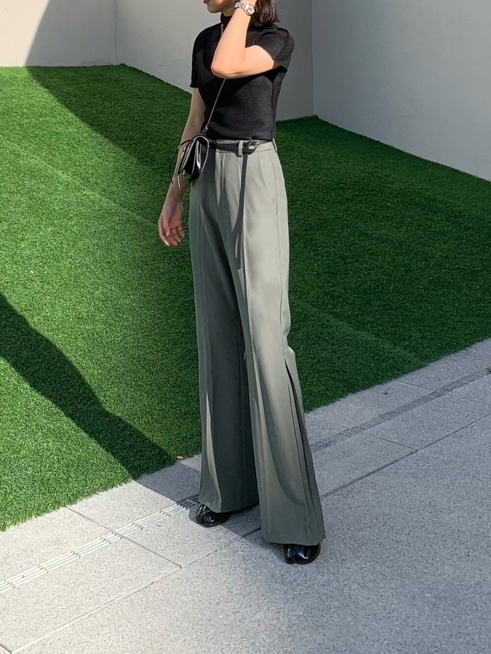 ブラック系のトップス、ブラック系のショルダーバッグ、グリーン系のその他パンツを着用したレディースの夏コーディネートの3枚目の写真