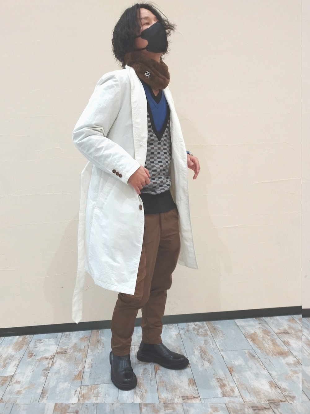 ホワイト系のトレンチコート、グレー系のニット/セーター、ブラウン系のパンツを着用したメンズの冬コーディネートの2枚目の写真