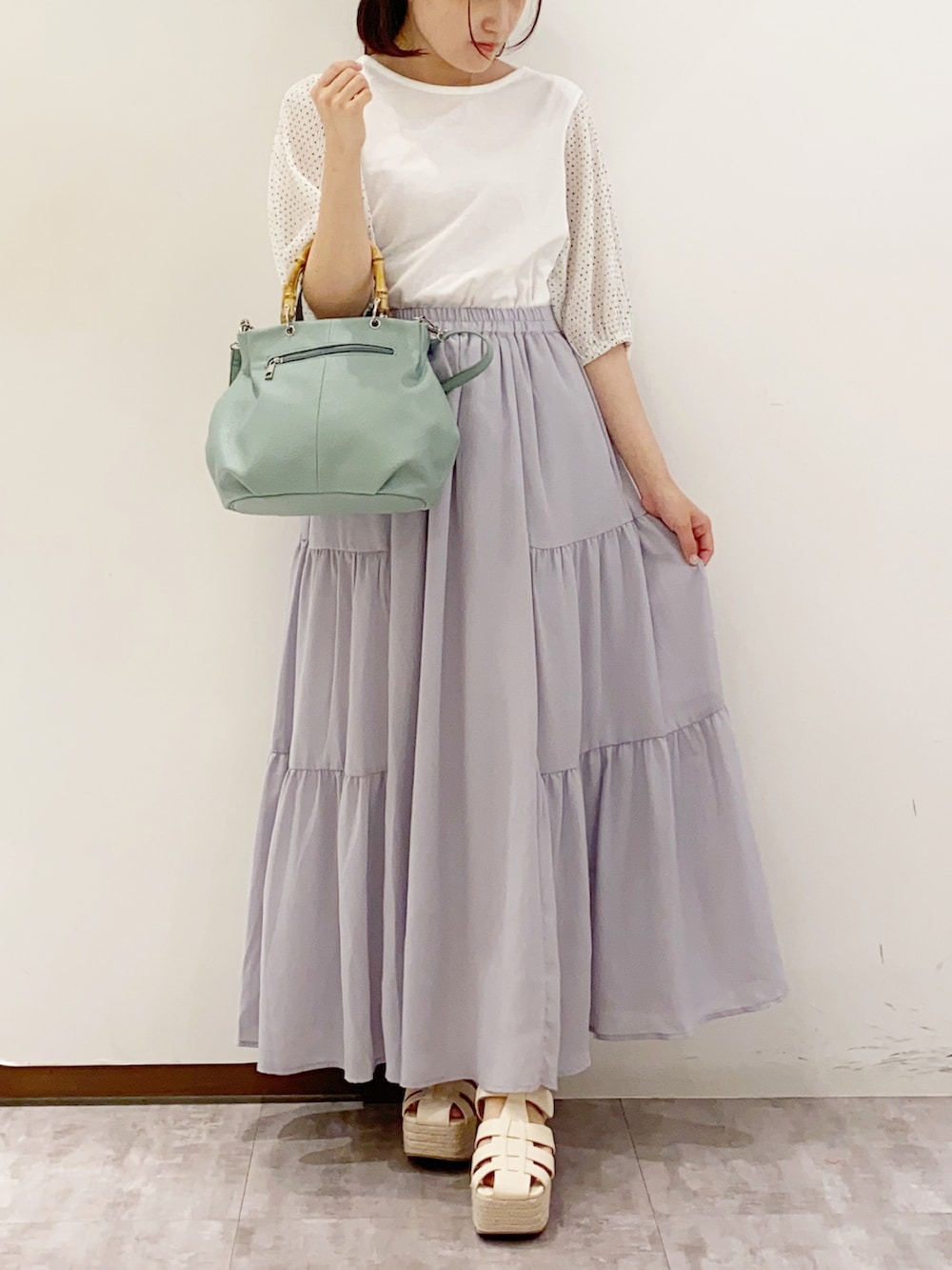 ホワイト系のTシャツ/カットソー、グリーン系のハンドバッグ、ホワイト系のサンダルを着用したレディースの夏コーディネートの4枚目の写真