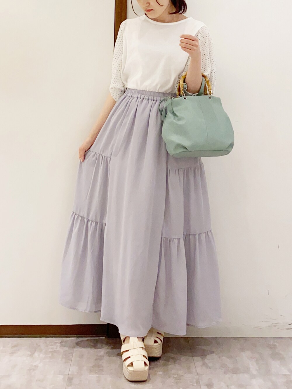 ホワイト系のTシャツ/カットソー、グリーン系のハンドバッグ、ホワイト系のサンダルを着用したレディースの夏コーディネートの2枚目の写真