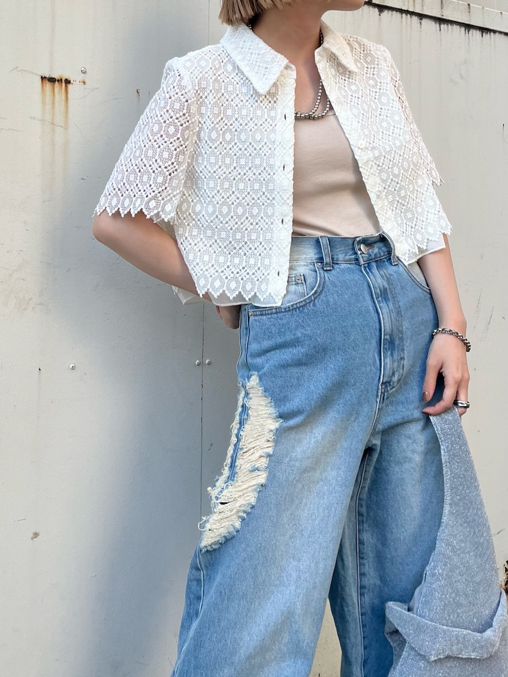 ブルー系のデニムパンツ、シルバー系のトートバッグ、ホワイト系のシャツ/ブラウスを着用したレディースの夏コーディネートの3枚目の写真