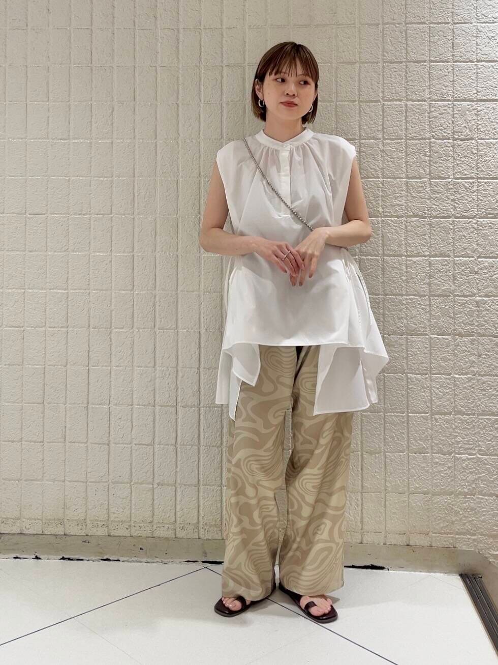 ベージュ系のその他パンツ、レッド系のサンダル、ホワイト系のシャツ/ブラウスを着用したレディースの春コーディネートの3枚目の写真