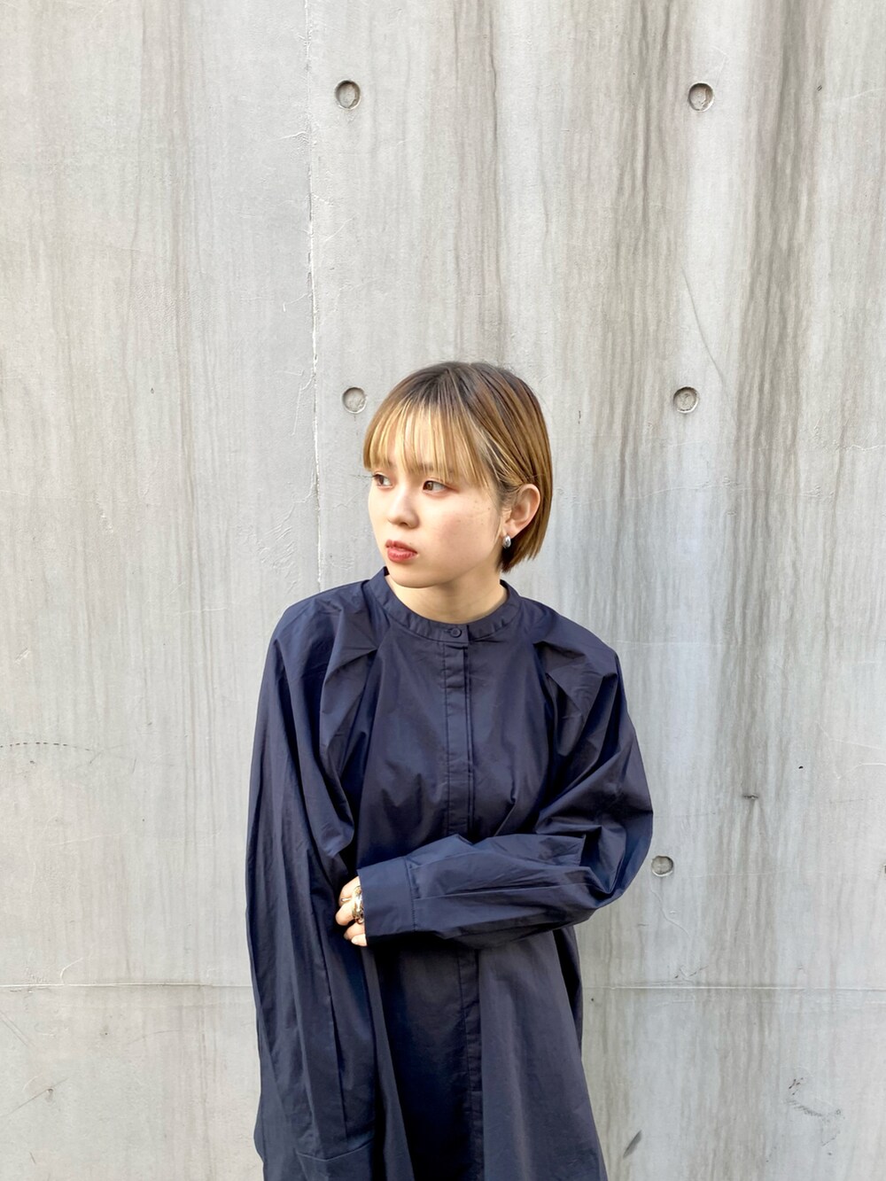 ブラック系のショルダーバッグ、ベージュ系のスカート、ブルー系のシャツ/ブラウスを着用したレディースの冬コーディネートの2枚目の写真