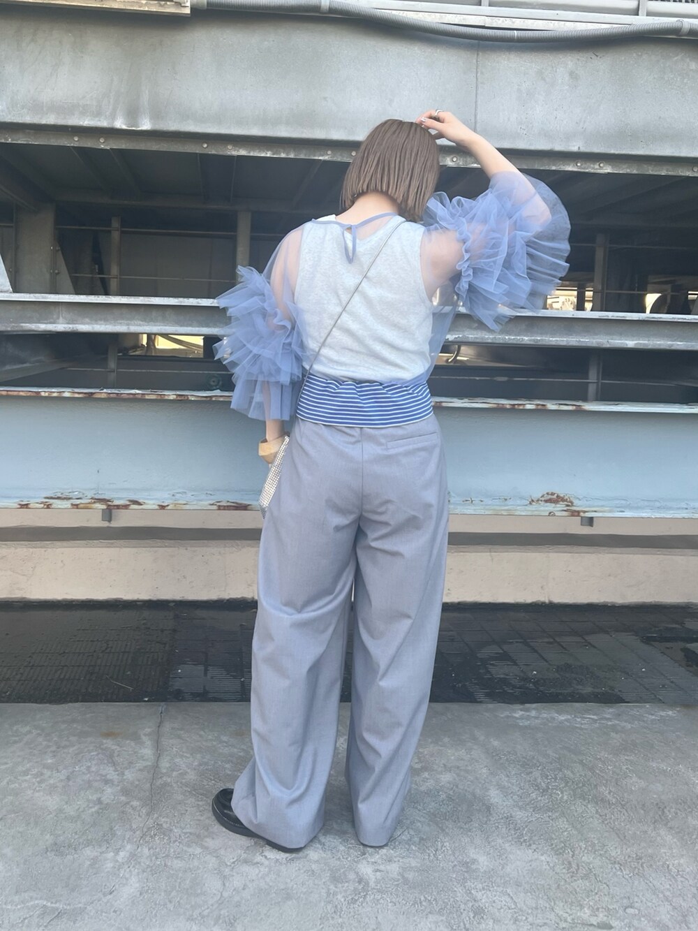 グレー系のその他パンツ、グリーン系のショルダーバッグ、ベージュ系のタンクトップを着用したレディースの春コーディネートの2枚目の写真