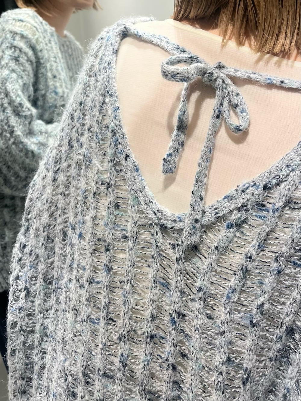 ブルー系のニット/セーター、ホワイト系のTシャツ/カットソー、グレー系のスカートを着用したレディースの秋コーディネートの3枚目の写真