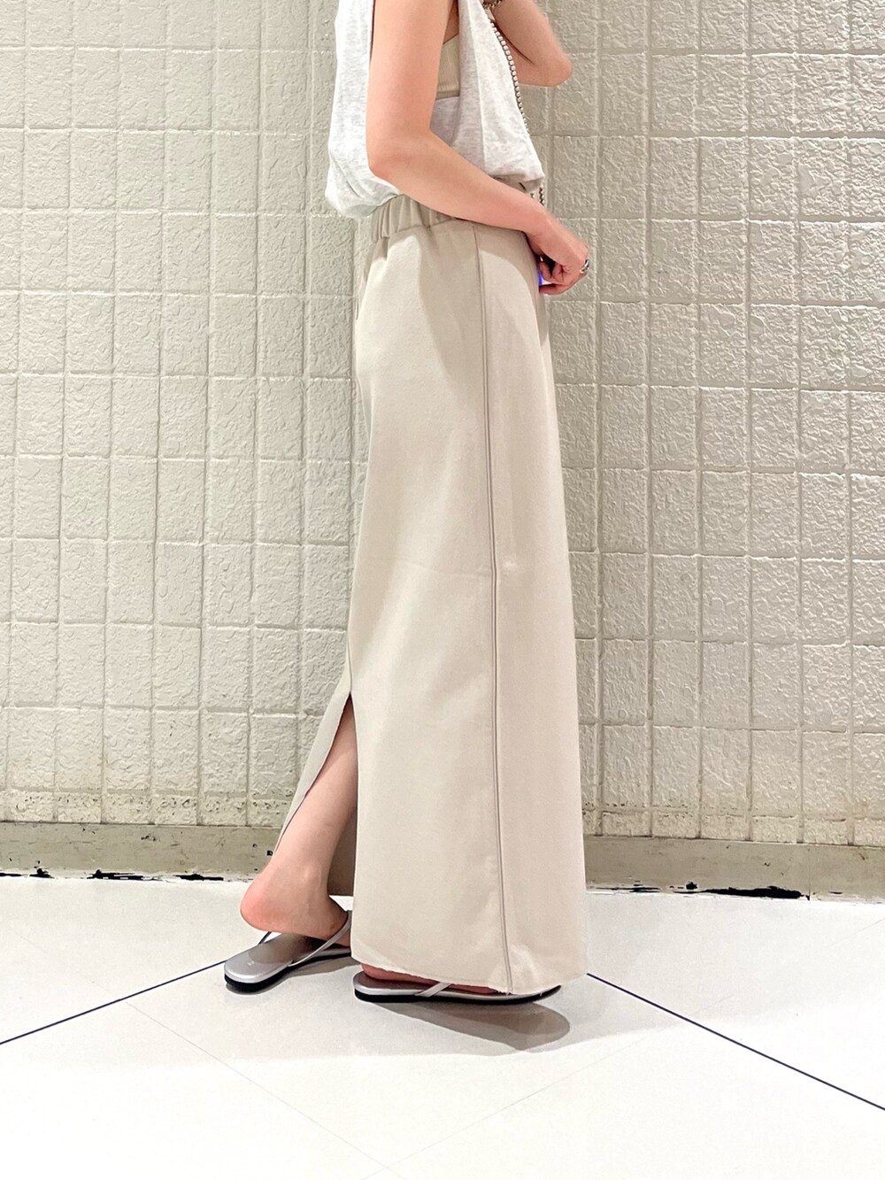 シルバー系のサンダル、ホワイト系のスカート、グレー系のTシャツ/カットソーを着用したレディースの夏コーディネートの3枚目の写真