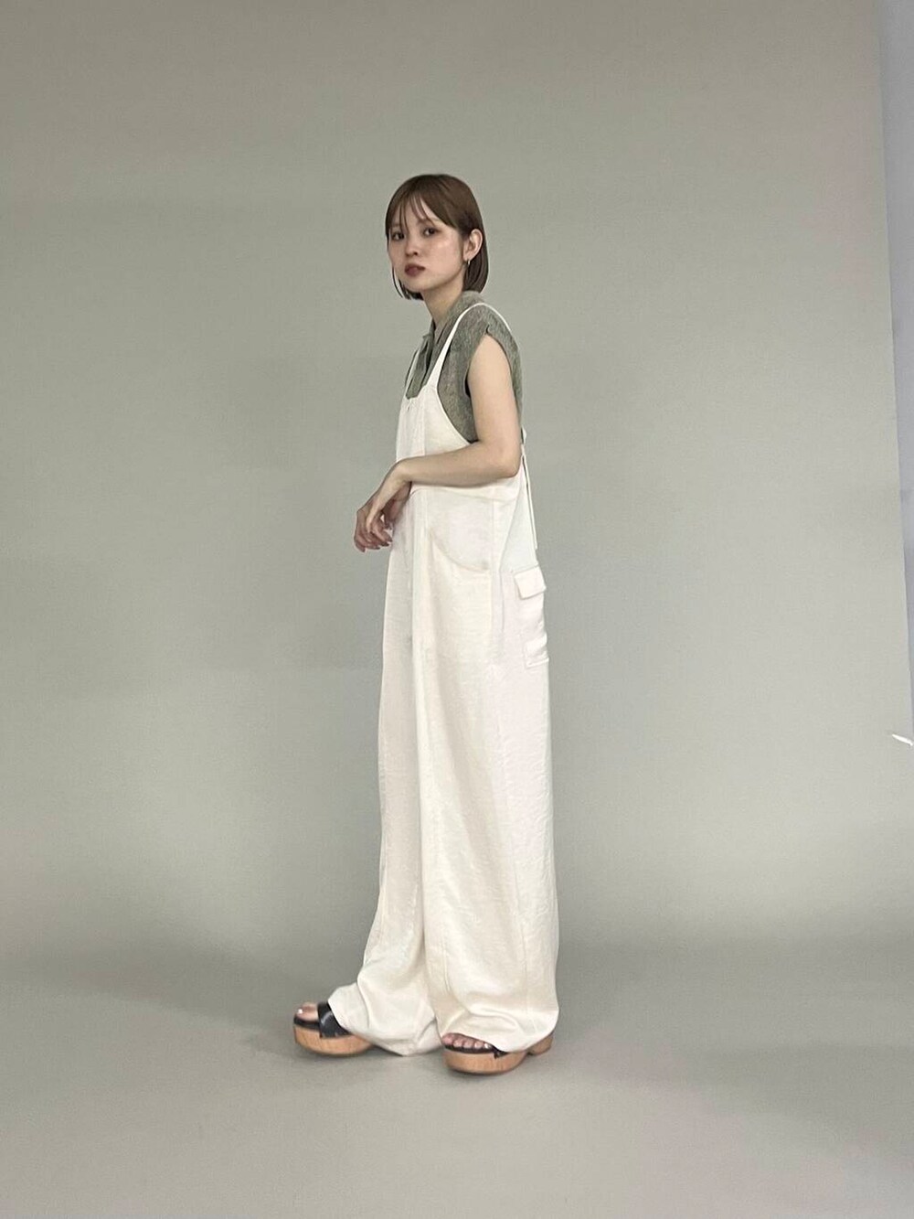 ブラウン系のサンダル、ベージュ系のニット/セーター、ホワイト系のサロペット/オーバーオールを着用したレディースの夏コーディネートの3枚目の写真