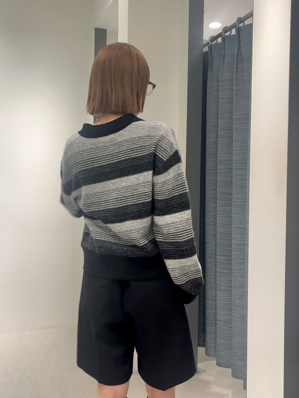 ブラック系のその他パンツ、ブラック系のカーディガン/ボレロ、ブラック系のブーツを着用したレディースの秋コーディネートの2枚目の写真