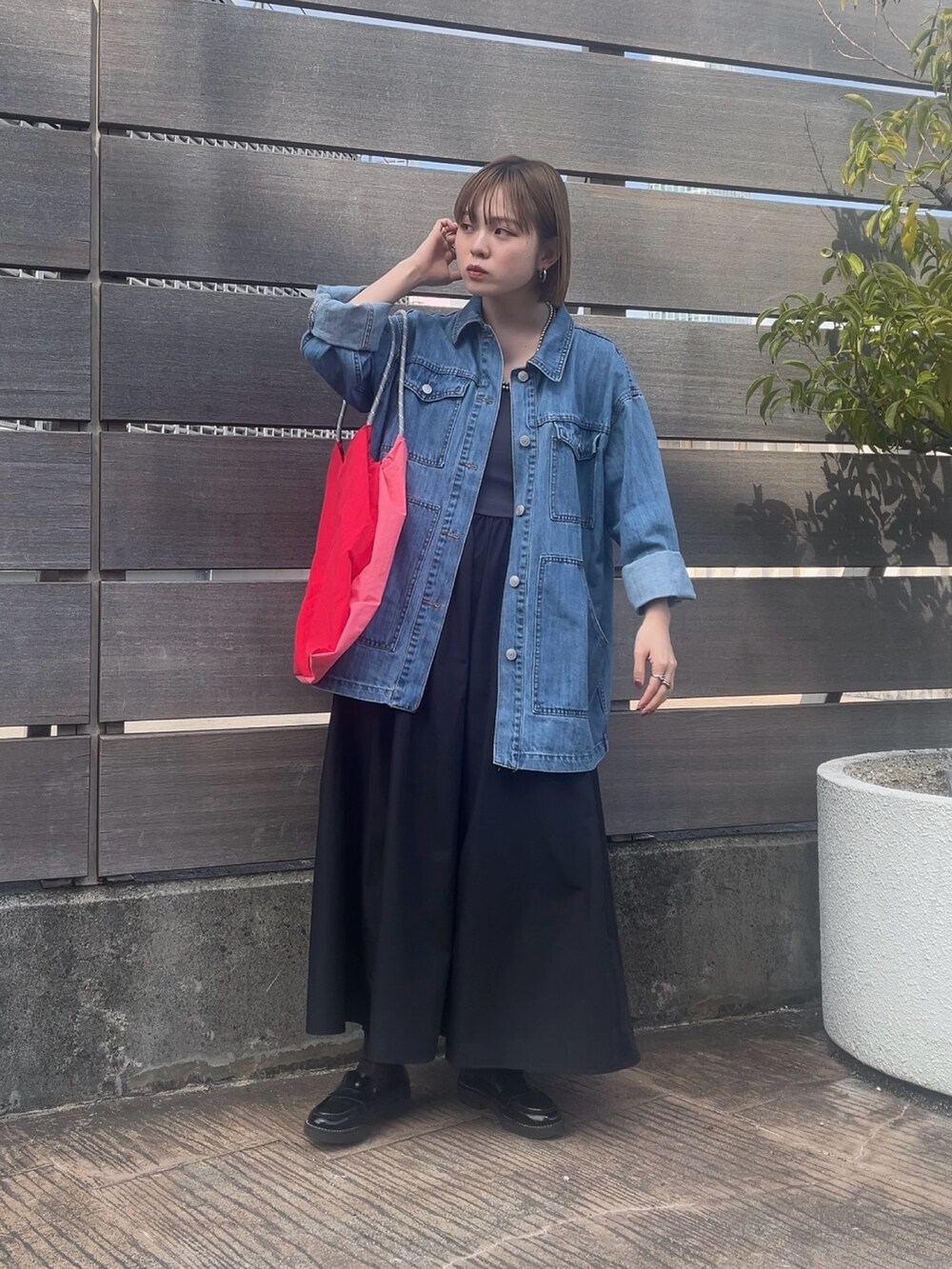 ピンク系のトートバッグ、ブルー系のデニムジャケット、グレー系のワンピースを着用したレディースの春コーディネートの3枚目の写真