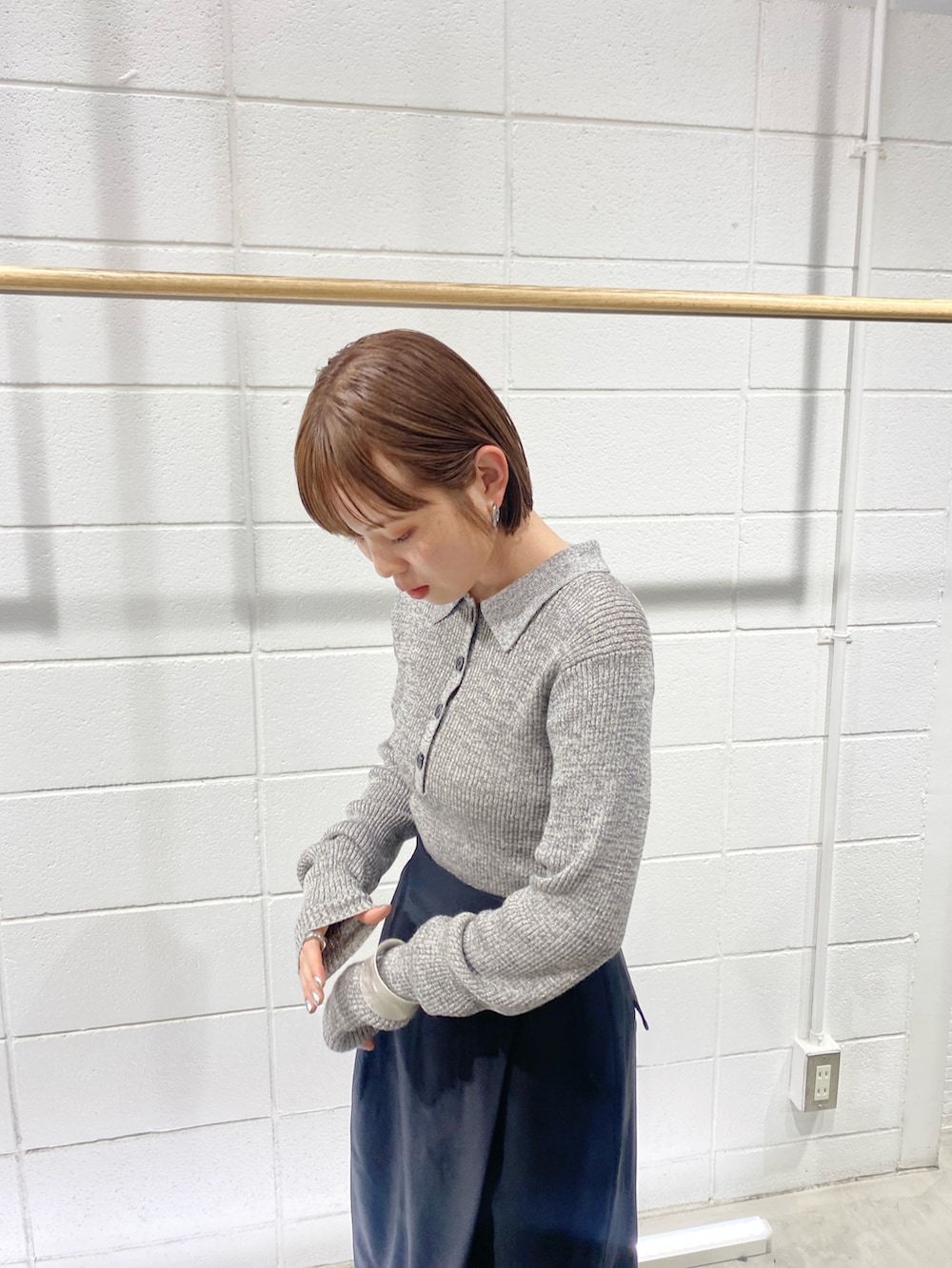 ブラック系のワンピース、グレー系のニット/セーター、シルバー系のブレスレットを着用したレディースの冬コーディネートの2枚目の写真