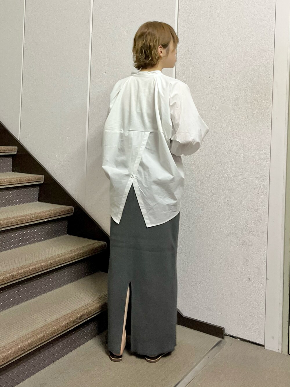 ホワイト系のシャツ/ブラウス、グレー系のスカート、ブラック系のボストンバッグを着用したレディースの夏コーディネートの2枚目の写真