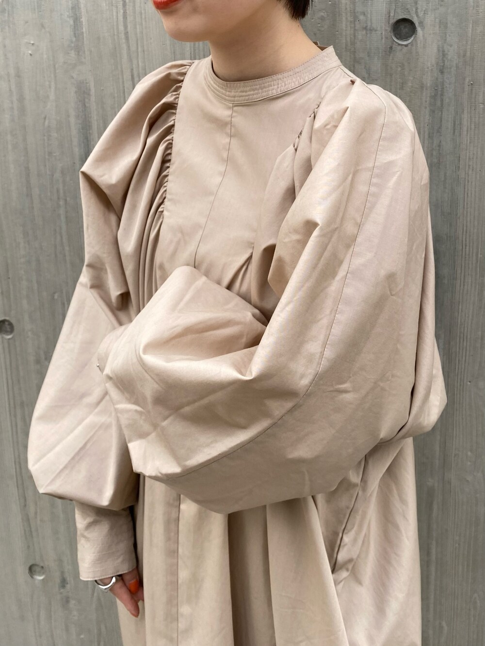 グレー系のブーツ、ベージュ系のワンピース、ピンク系のカーディガン/ボレロを着用したレディースの春コーディネートの4枚目の写真