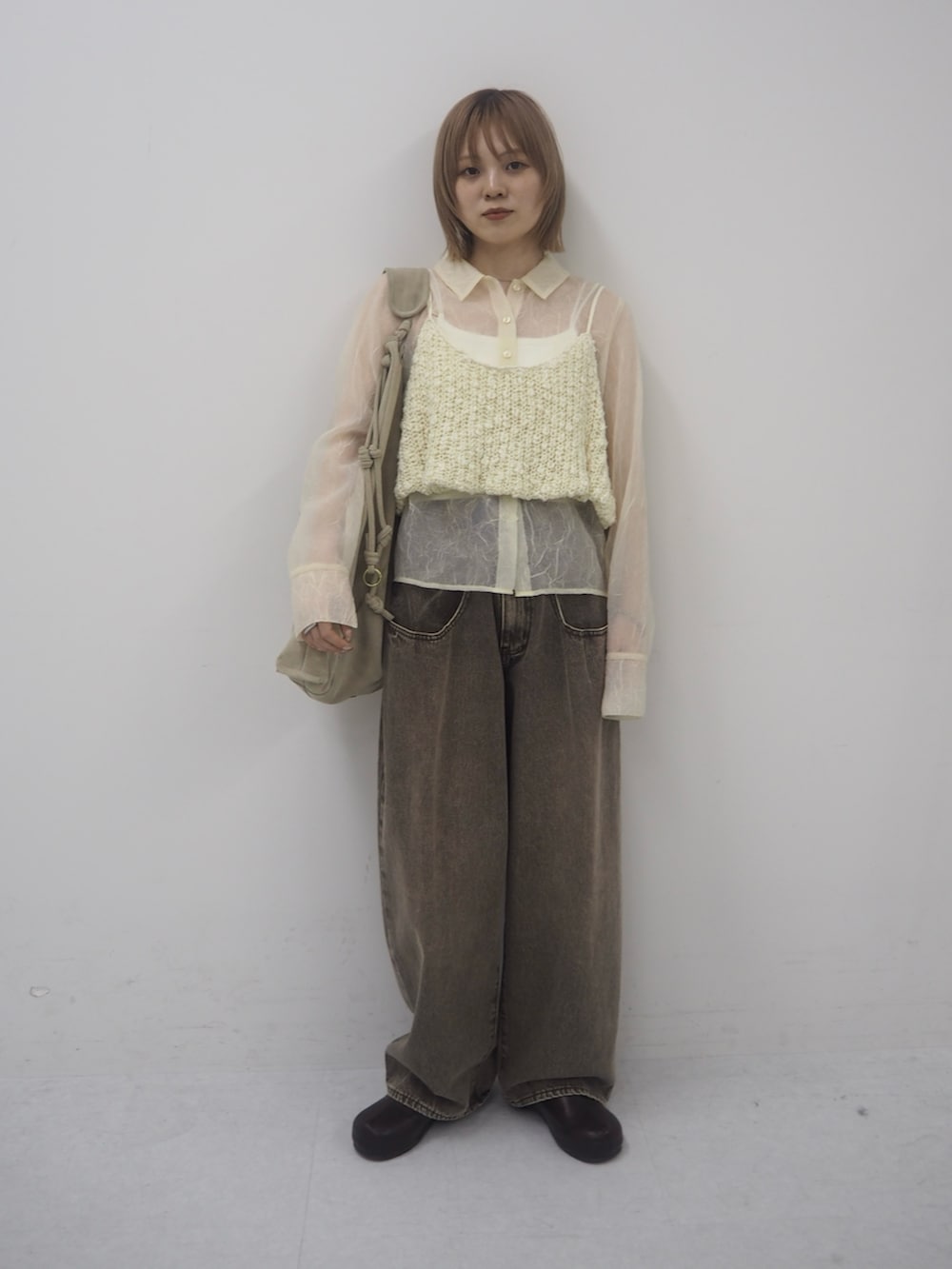 ブラウン系のデニムパンツ、ホワイト系のニット/セーター、ブラック系のその他シューズを着用したレディースの冬コーディネートの3枚目の写真