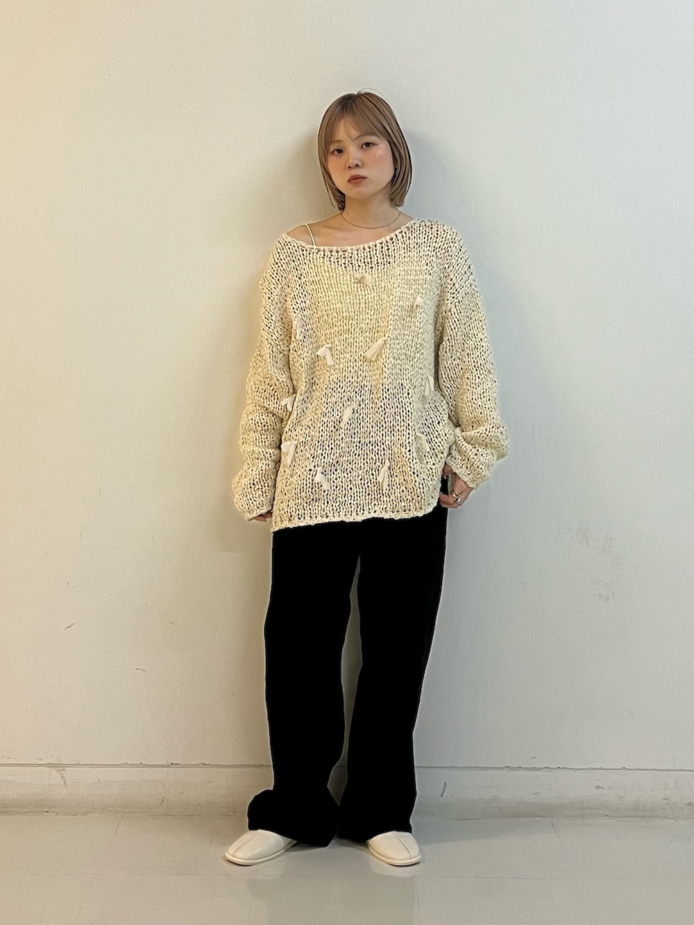 ホワイト系のニット/セーター、ホワイト系のキャミソール、ブラック系のデニムパンツを着用したレディースの冬コーディネートの2枚目の写真