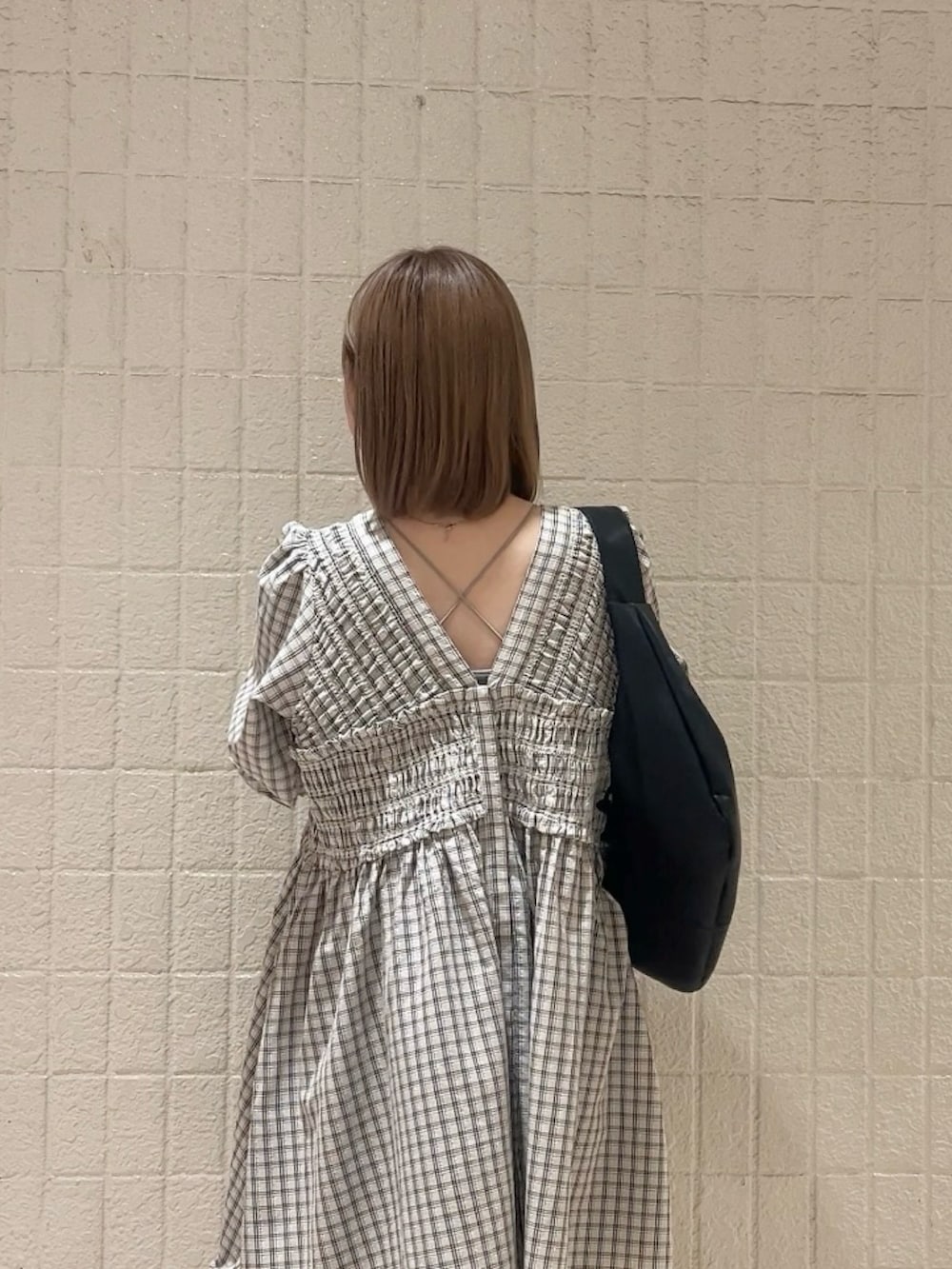 ベージュ系のワンピース、ブラック系のその他パンツ、ブラック系のショルダーバッグを着用したレディースの春コーディネートの3枚目の写真