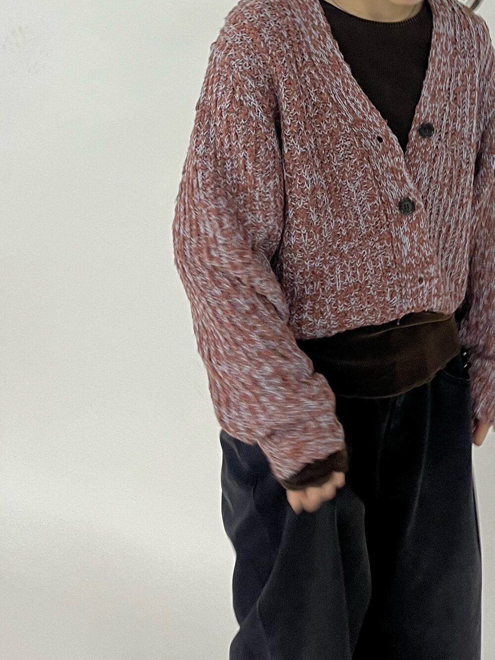 ブラック系のデニムパンツ、ブラウン系のスニーカー、ブラウン系のニット/セーターを着用したレディースの秋コーディネートの4枚目の写真