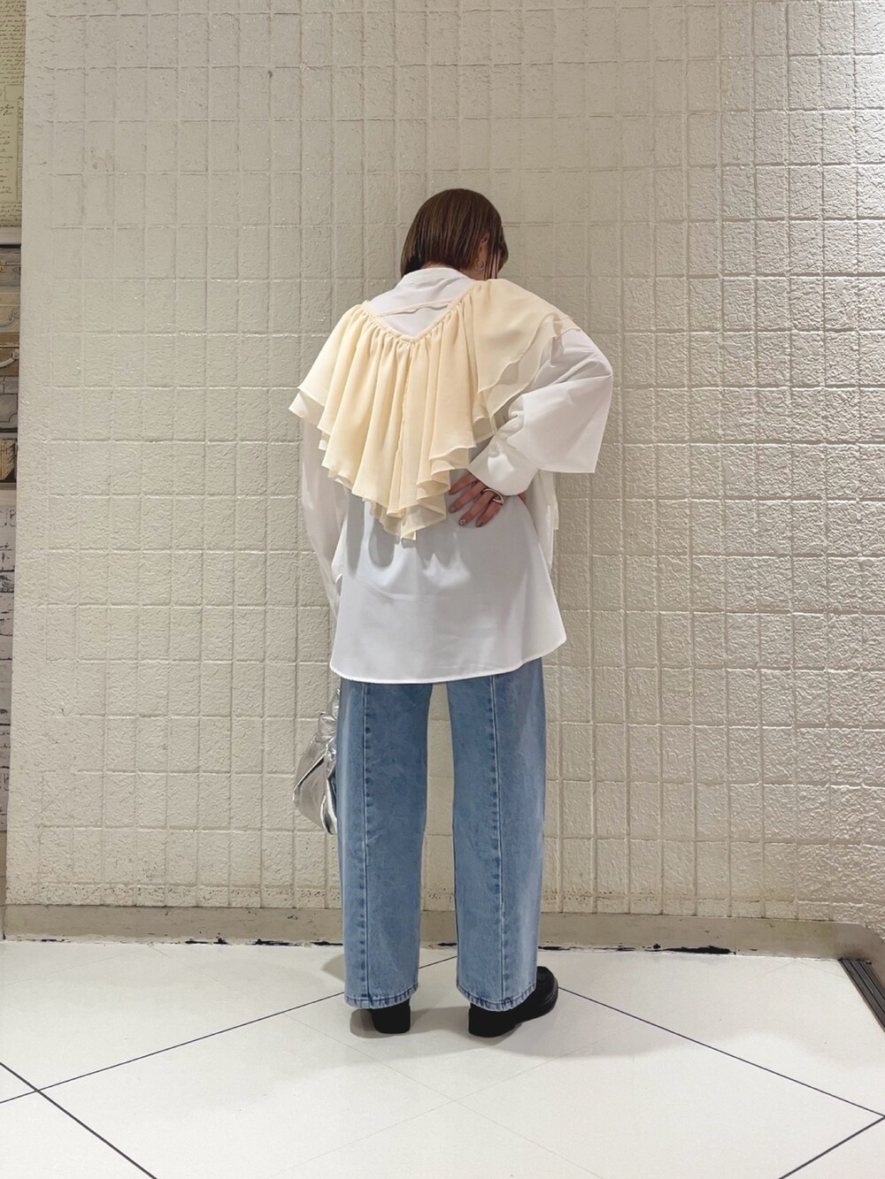 ホワイト系のシャツ/ブラウス、ブルー系のデニムパンツ、シルバー系のハンドバッグを着用したレディースの春コーディネートの2枚目の写真