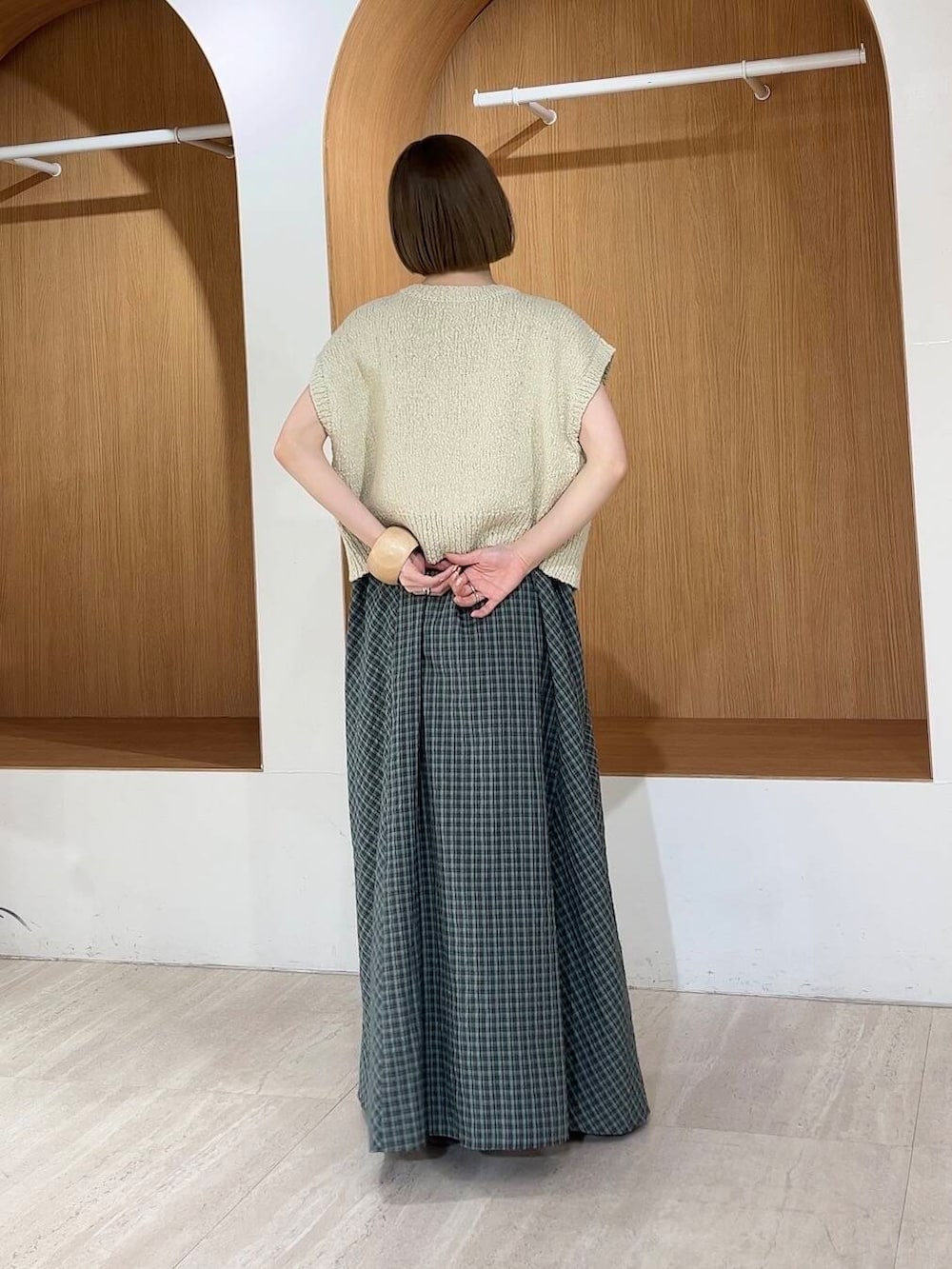 ベージュ系のニット/セーター、グリーン系のワンピース、レッド系のサンダルを着用したレディースの春コーディネートの2枚目の写真