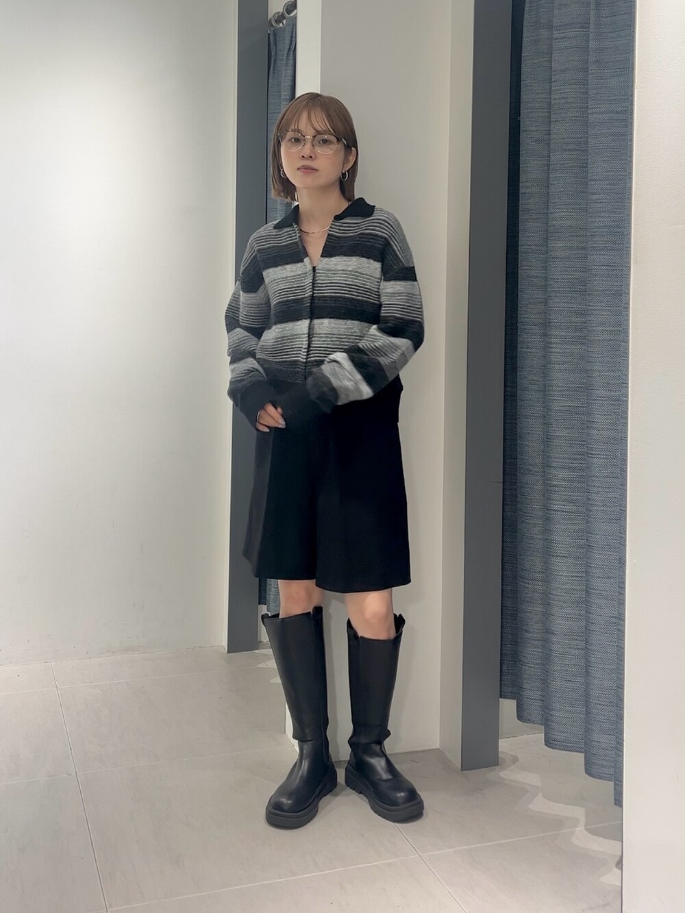 ブラック系のその他パンツ、ブラック系のカーディガン/ボレロ、ブラック系のブーツを着用したレディースの秋コーディネートの4枚目の写真