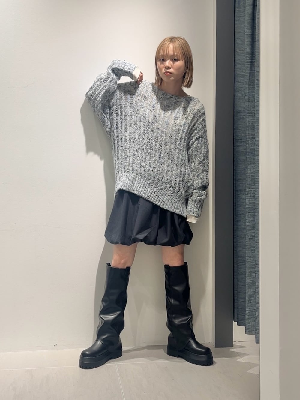 ブルー系のニット/セーター、ホワイト系のTシャツ/カットソー、グレー系のスカートを着用したレディースの秋コーディネートの2枚目の写真