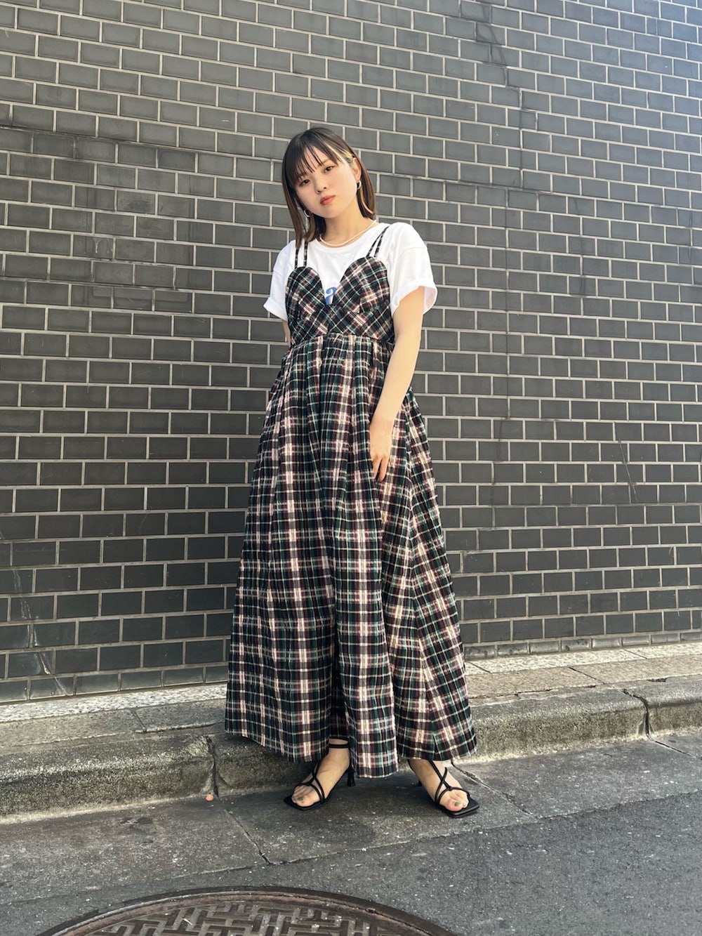 ブルー系のワンピース、ブラック系のサンダル、ホワイト系のTシャツ/カットソーを着用したレディースの春コーディネートの2枚目の写真