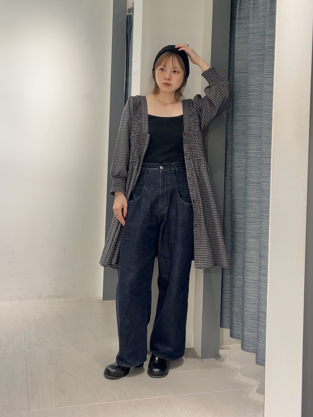 ブルー系のデニムパンツ、ブラウン系のワンピース、ブラック系のサンダルを着用したレディースの春コーディネートの2枚目の写真