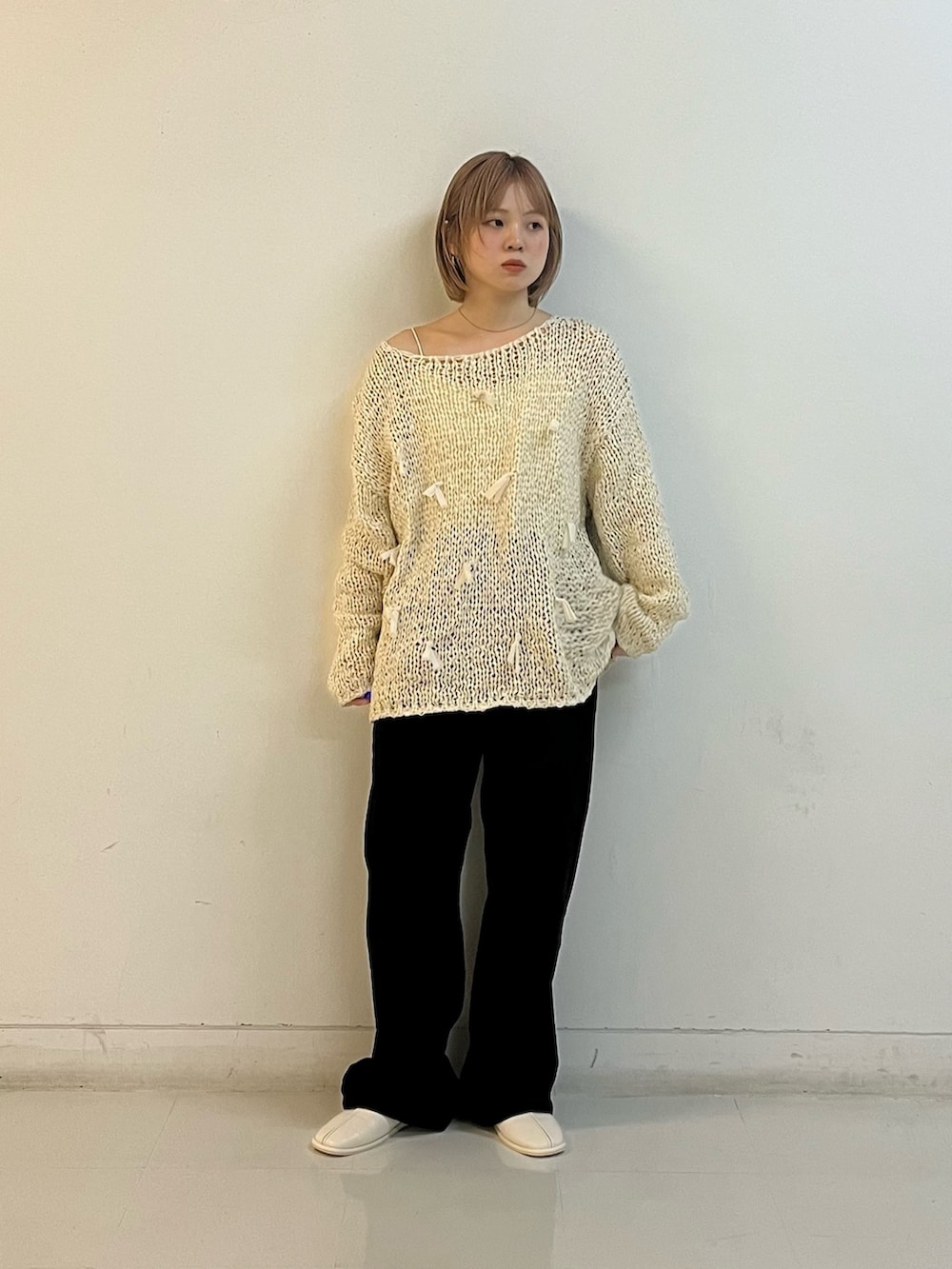 ホワイト系のニット/セーター、ホワイト系のキャミソール、ブラック系のデニムパンツを着用したレディースの冬コーディネートの5枚目の写真