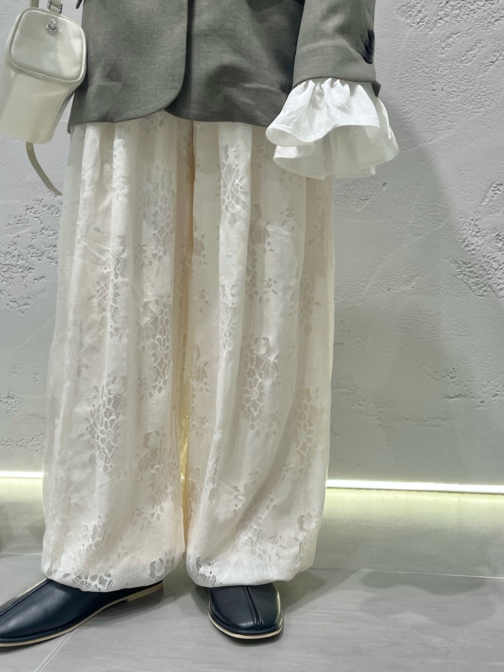 グレー系のその他アウター、ホワイト系のその他パンツ、ブラック系のパンプスを着用したレディースの冬コーディネートの2枚目の写真